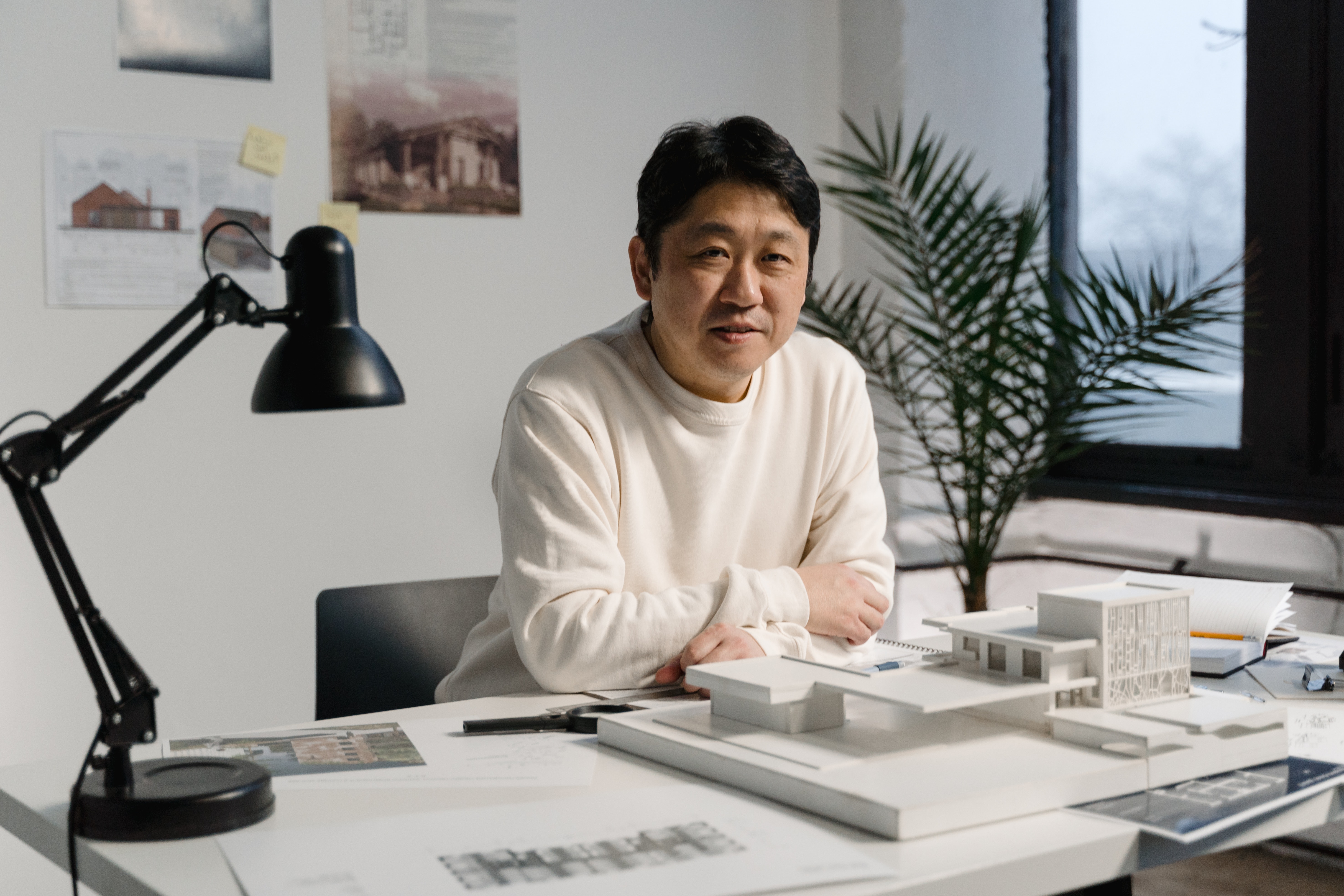 a designer sitting at his desk,with an architectural model